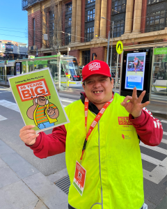 Vendor Jeffery smiling while holding a print out of his illustration.