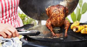 A chicken on a cider can cooking on the BBQ.