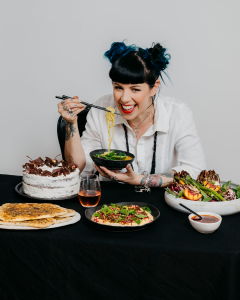 Shannon Martinez laughing as she eats food she's cooked.